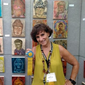 A woman holding a ribbon in front of many paintings.