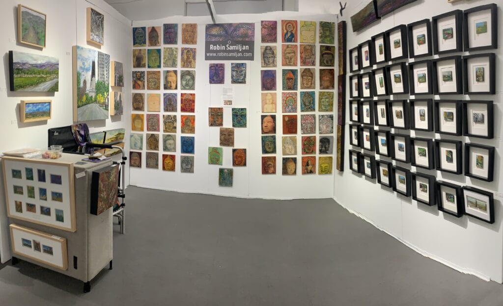 A woman holding a ribbon in front of many paintings.