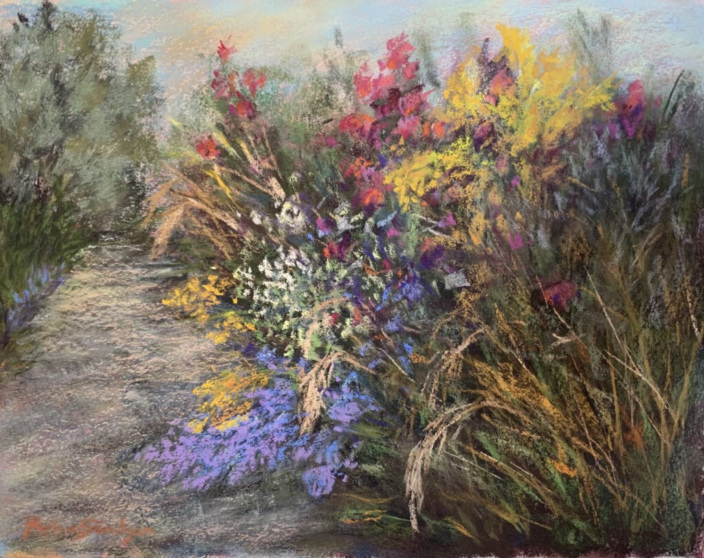 Colorful flowers alongside a garden pathway.