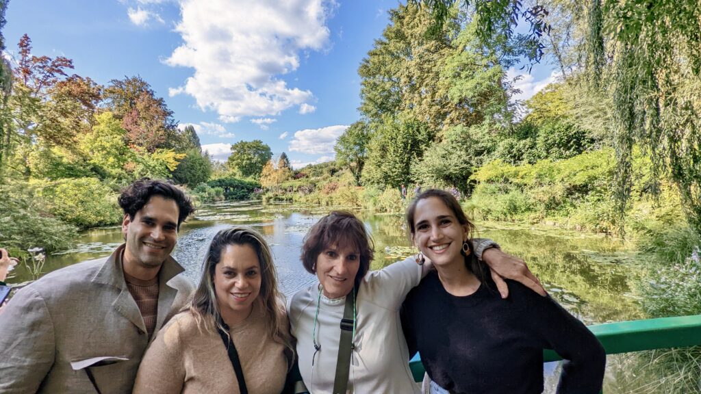 Four people posing by a scenic river.