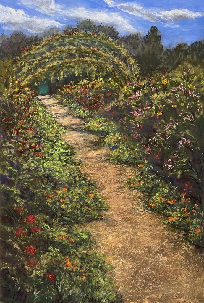 Garden path with archway and blooming flowers.