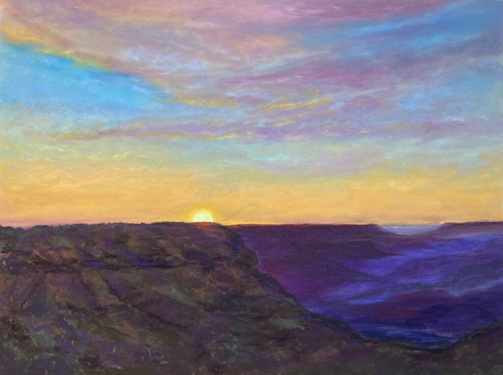 Sunset over canyon with colorful sky.