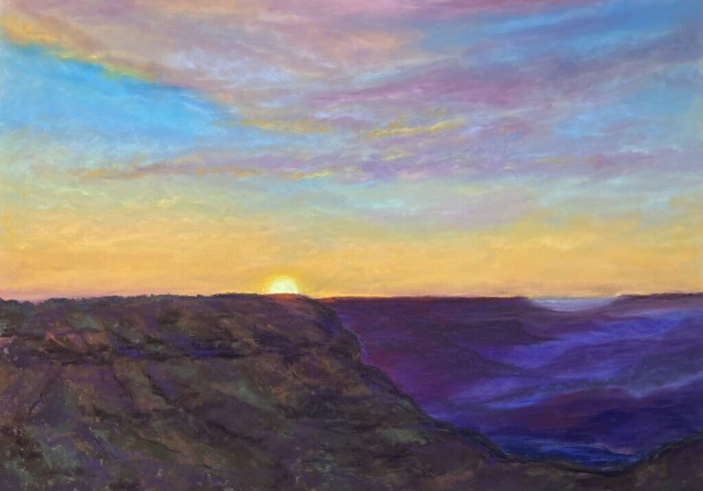 Sunset over canyon with colorful sky.