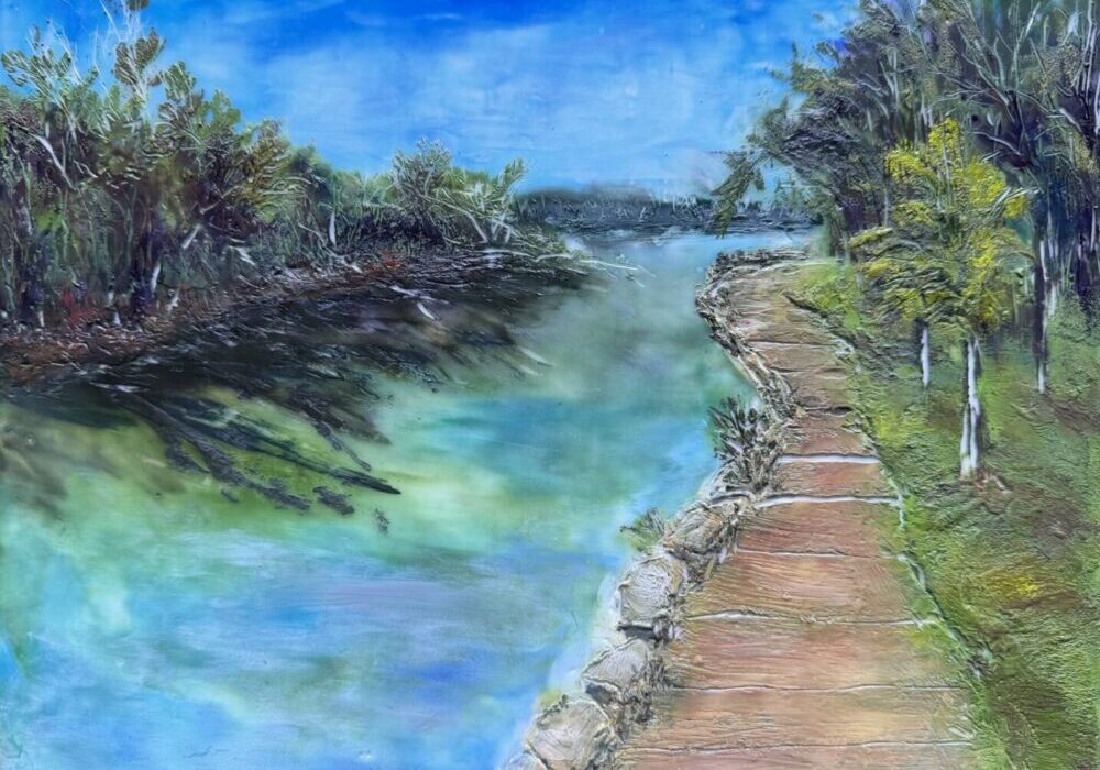 Wooden boardwalk beside calm river and trees