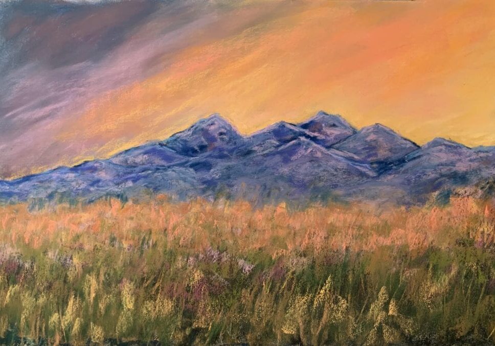 Colorful landscape with mountains and grassy field.