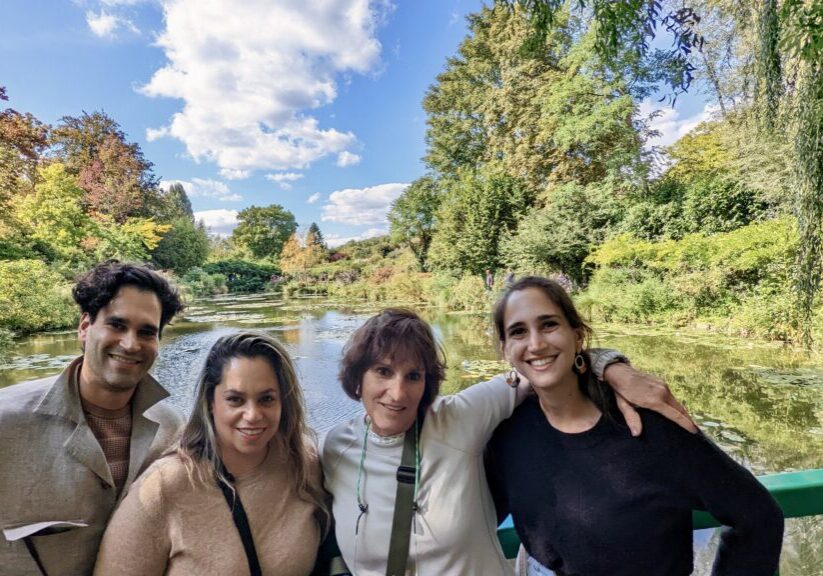Four people posing by a scenic river.