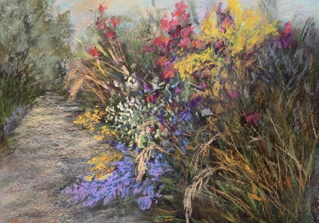 Colorful flowers alongside a garden pathway.